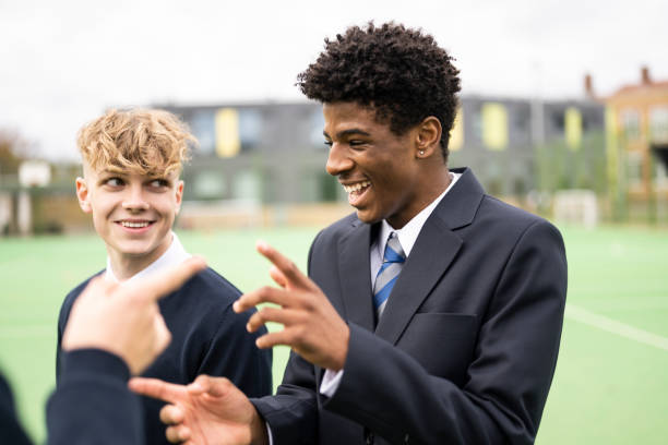 Sixth-form students laughing on a school sports pitch